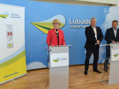 Marszałek Elżbieta Anna Polak przy mównicy. W tle szefowie szpitali.