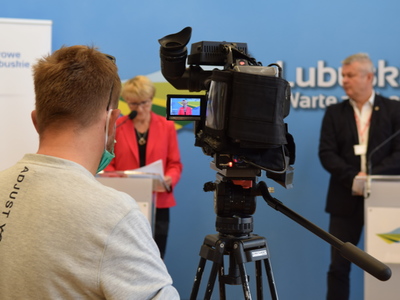 Zdjęcie operatora kamery nagrywającego konferencję.