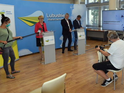 Marszałek Elżbieta Anna Polak przy mównicy. W tle szefowie szpitali.