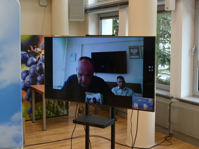 Telewizor służący do wideokonferencji z uczestnikami konferencji prasowej.