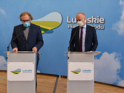 Uczestnicy konferencji przy mównicy.