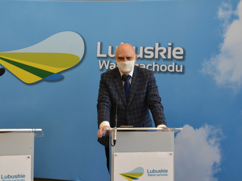 Uczestnicy konferencji przy mównicy.