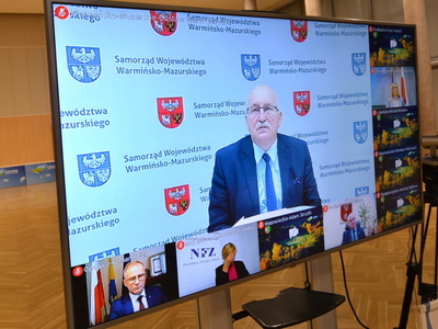 Uczestnicy konwentu pokazani na telewizorach.