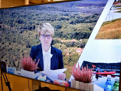 Uczestnicy konwentu pokazani na telewizorach.