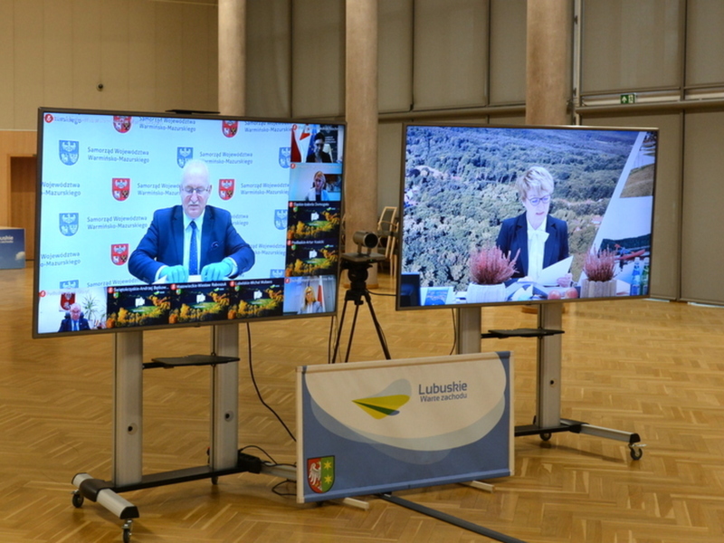Uczestnicy konwentu pokazani na telewizorach.