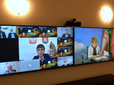 Uczestnicy wideokonferencji na telewizorach.