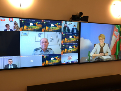 Uczestnicy wideokonferencji na telewizorach.