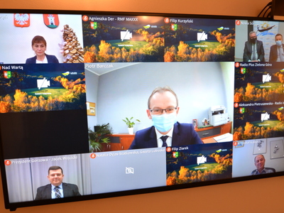 Uczestnicy wideokonferencji na telewizorach.