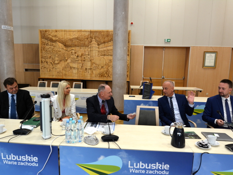 Wiele osób siedzących przy długim stole.