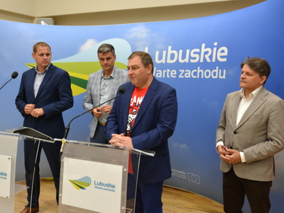 Uczestnicy konferencji przy mównicach na tle ścianki promocyjnej z napisem Lubuskie. 