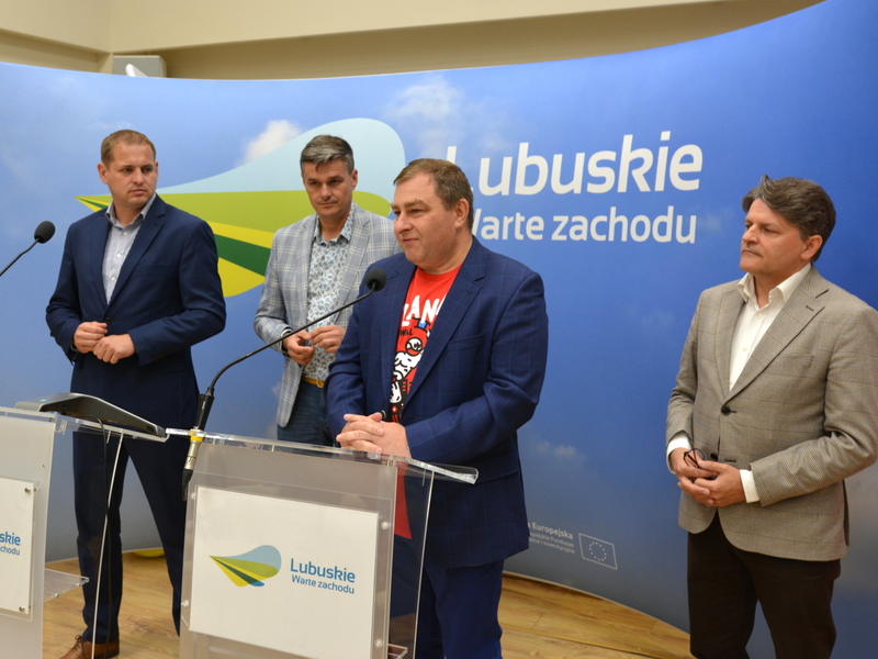 Uczestnicy konferencji przy mównicach na tle ścianki promocyjnej z napisem Lubuskie.