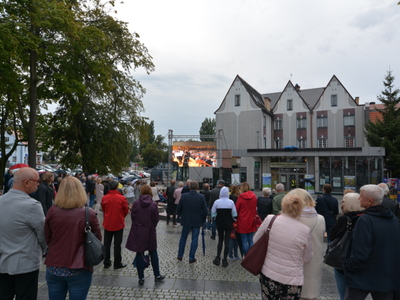 Widzowie przed filharmonią oglądający koncert na telebimie. 