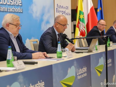 Konsultacje społeczne w sprawie Europejskich Funduszy Województwa Lubuskiego 2021-2027. Przy mikrofonie członek zarządu woj. lubuskiego, Marcin Jabłoński. Z lewej członek zarządu Tadeusz Jędrzejczak. Z prawej wicemarszałkowie, Stanisław Tomczyszyn oraz Łukasz Porycki.