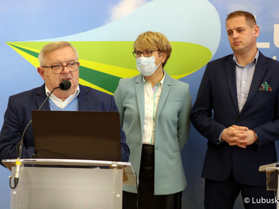Konferencja prasowa Zarządu Województwa Lubuskiego dotycząca projektu budżetu na 2022 rok. Przy mikrofonie członek zarządu Tadeusz Jędrzejczak. Z tyłu od lewej stoją: marszałek Elżbieta Anna Polak oraz wicemarszałek Łukasz Porycki.