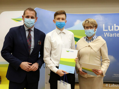 Marszałek Elżbieta Anna Polak oraz wicemarszałek Łukasz Porycki na pamiątkowym zdjęciu ze studentem, który otrzymał stypendium motywujące