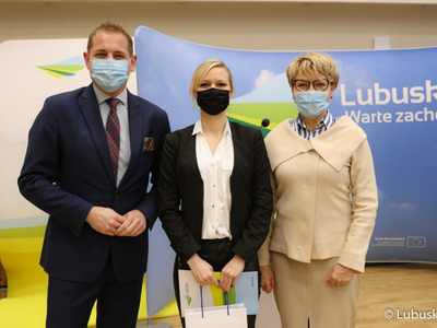 Marszałek Elżbieta Anna Polak oraz wicemarszałek Łukasz Porycki na pamiątkowym zdjęciu ze studentką, która otrzymała stypendium motywujące