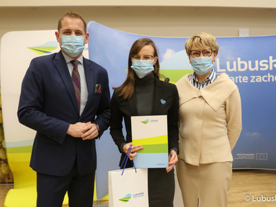Marszałek Elżbieta Anna Polak oraz wicemarszałek Łukasz Porycki na pamiątkowym zdjęciu ze studentką, która otrzymała stypendium motywujące