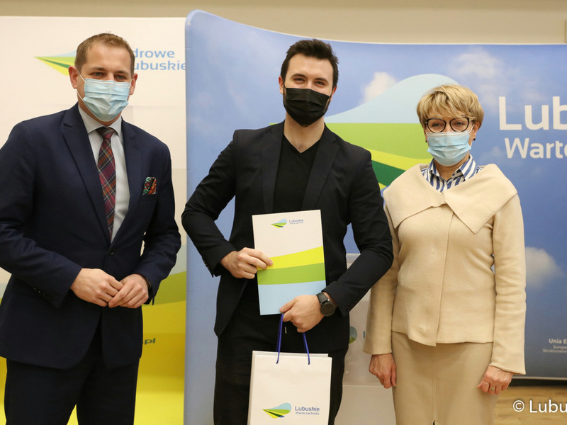 Marszałek Elżbieta Anna Polak oraz wicemarszałek Łukasz Porycki na pamiątkowym zdjęciu ze studentem, który otrzymał stypendium motywujące