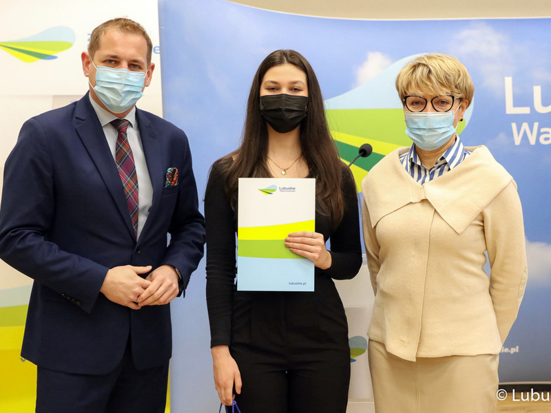 Marszałek Elżbieta Anna Polak oraz wicemarszałek Łukasz Porycki na pamiątkowym zdjęciu ze studentką, która otrzymała stypendium motywujące