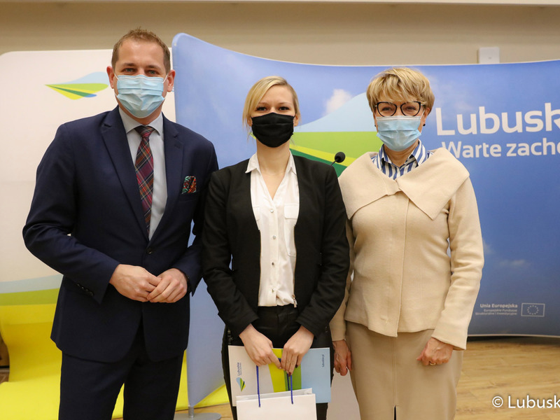 Marszałek Elżbieta Anna Polak oraz wicemarszałek Łukasz Porycki na pamiątkowym zdjęciu ze studentką, która otrzymała stypendium motywujące