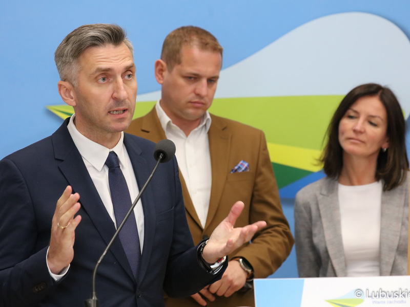 Poseł RP Waldemar Sługocki (przy mikrofonie) podczas konferencji prasowej. Za nim Wicemarszałek Województwa Lubuskiego Łukasz Porycki oraz kanclerz UZ Katarzyna Łasińska