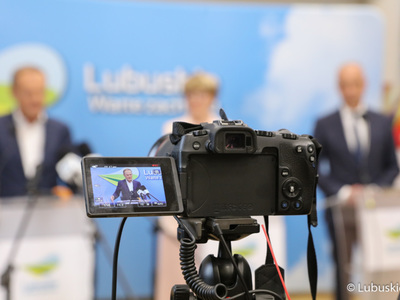 Przewodniczący PO Donald Tusk (z lewej) w obiektywie kamery na briefingu prasowym w sali prasowej UMWL