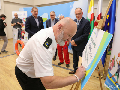 Prezes WOPR Lubuskie Robert Frydrych podpisuje symboliczny czek z dotacją dla lubuskiego WOPR 

