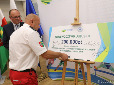 Prezes WOPR Gubin Jacek Czerepko podpisuje symboliczny czek z dotacją dla lubuskiego WOPR 