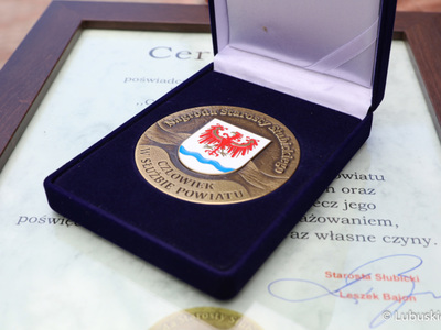 Medal i certyfikat poświadczający otrzymanie nagrody starosty słubickiego "Człowiek w służbie powiatu" dla marszałek Elżbiety Anny Polak 