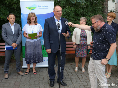 Wicemarszałek Stanisław Tomczyszyn (przy mikrofonie) przemawia podczas konferencji prasowej przed budynkiem Urzędu Marszałkowskiego w Zielonej Górze 