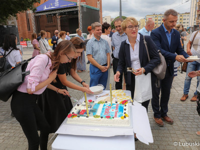 Uczestnicy konferencji prasowej dot. powrotu linii tramwajowej numer 2 na gorzowskie Piaski kroją okolicznościowy tort