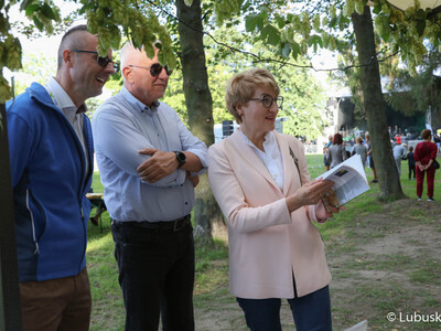 Marszałek woj. lubuskiego Elżbieta Anna Polak, burmistrz Kożuchowa Paweł Jagasek oraz Senator RP Wadim Tyszkiewicz odwiedzają jedno ze stoisk Kół Gospodyń Wiejskich na Święcie Województwa Lubuskiego w Kożuchowie