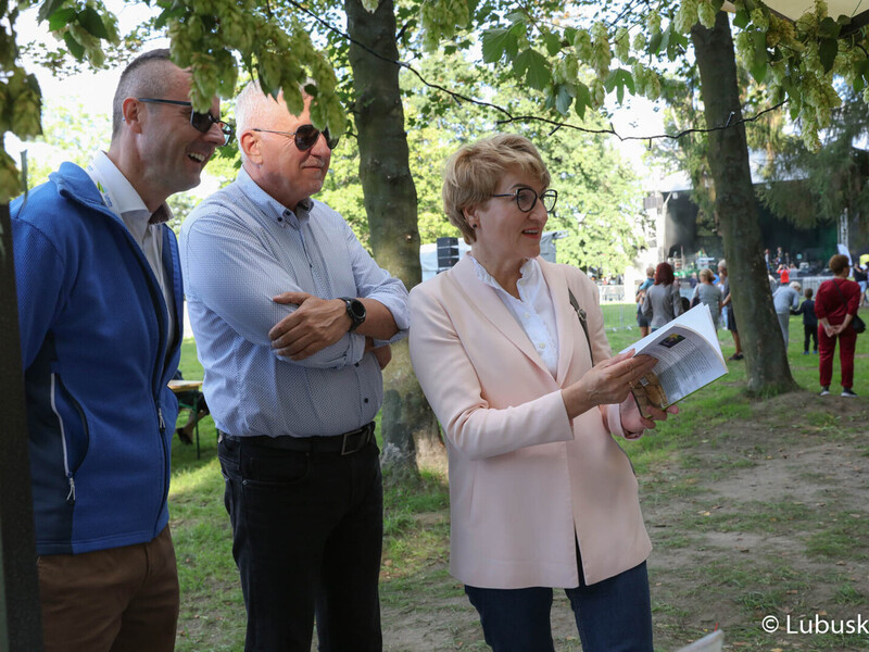 Marszałek woj. lubuskiego Elżbieta Anna Polak, burmistrz Kożuchowa Paweł Jagasek oraz Senator RP Wadim Tyszkiewicz odwiedzają jedno ze stoisk Kół Gospodyń Wiejskich na Święcie Województwa Lubuskiego w Kożuchowie