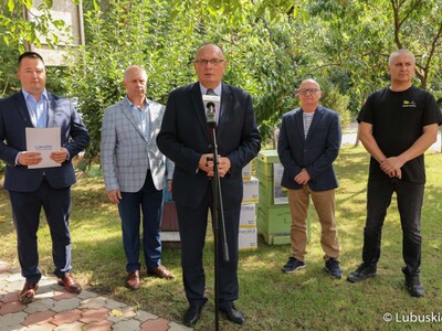 Wicemarszałek Województwa Lubuskiego Stanisław Tomczyszyn (przy mikrofonie) podczas konferencji prasowej dotyczącej etapu realizacji projektu wsparcia lubuskich pszczelarzy „zakup węzy pszczelej”. 
