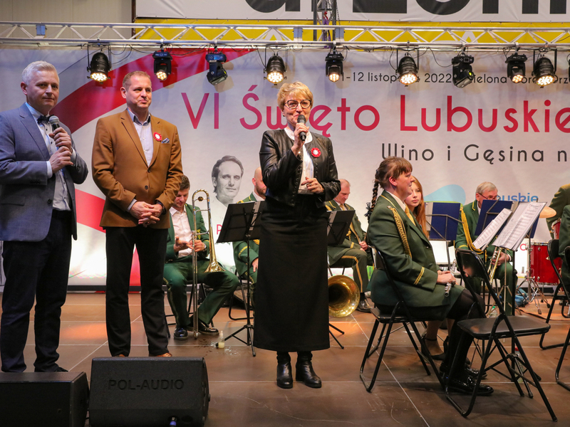 Marszałek Województwa Lubuskiego Elżbieta Anna Polak przemawia podczas oficjalnego otwarcia VI Święta Młodego Lubuskiego Wina w Wojewódzkim Ośrodku Sportu i Rekreacji w Zielonej Górze Drzonkowie. Obok (w brązowej marynarce) stoi Wicemarszałek Województwa Lubuskiego Łukasz Porycki.