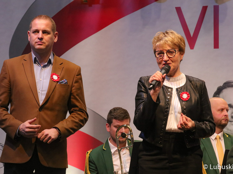 Marszałek Województwa Lubuskiego Elżbieta Anna Polak przemawia podczas oficjalnego otwarcia VI Święta Młodego Lubuskiego Wina w Wojewódzkim Ośrodku Sportu i Rekreacji w Zielonej Górze Drzonkowie. Obok (w brązowej marynarce) stoi Wicemarszałek Województwa Lubuskiego Łukasz Porycki.