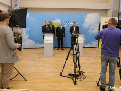 Członek Zarządu PZPN i Prezes LZPN Robert Skowron (przy mikrofonie) przemawia podczas konferencji prasowej na temat nawadniania boisk piłkarskich i programu trybuna. Z tyłu: Wicemarszałek Województwa Lubuskiego Stanisław Tomczyczyn, Radny Województwa Lubuskiego Zbigniew Kołodziej oraz dyrektor Departamentu Programów Rozwoju Obszarów Wiejskich Arkadiusz Dąbrowski.