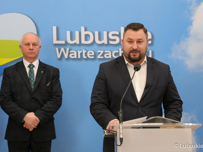 Dyrektor Departamentu Programów Rozwoju Obszarów Wiejskich Arkadiusz Dąbrowski (przy mikrofonie) przemawia podczas konferencji prasowej na temat nawadniania boisk piłkarskich i programu trybuna. Z tyłu Radny Województwa Lubuskiego Zbigniew Kołodziej.