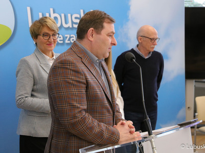 Uczestnicy konferencji prasowej poświęconej wsparciu samorządu woj. lubuskiego dla Lubuskiego Lata Filmowego. Przy mikrofonie: radny województwa lubuskiego Grzegorz Potęga. Z tyłu: Marszałek Województwa Lubuskiego  Elżbieta Anna Polak oraz prezes zarządu Klubu Kultury Filmowej Tomasz Piersiak.
