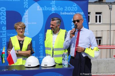 Uczestnicy konferencji prasowej na dachu budynku Pawilonu Rehabilitacyjnego w Lubuskim Centrum Ortopedii w Świebodzinie. Przy mikrofonie członek zarządu woj. lubuskiego Marcin Jabłoński. 