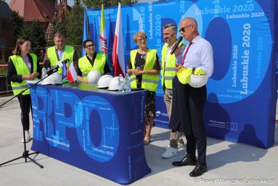 Uczestnicy konferencji prasowej na dachu budynku Pawilonu Rehabilitacyjnego w Lubuskim Centrum Ortopedii w Świebodzinie. Przy mikrofonie członek zarządu woj. lubuskiego Marcin Jabłoński. 