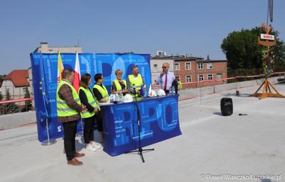 Uczestnicy konferencji prasowej na dachu budynku Pawilonu Rehabilitacyjnego w Lubuskim Centrum Ortopedii w Świebodzinie. Przy mikrofonie członek zarządu woj. lubuskiego Marcin Jabłoński. 