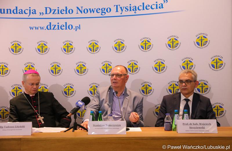 Podczas konferencji prasowej w parafii pw. Ducha Świętego w Zielonej Górze wicemarszałek Stanisław Tomczyszyn (w środku) podkreślał, że cieszy się, że te kilkaset osób przybyło do regionu lubuskiego. To są osoby, które otrzymują wsparcie z fundacji "Dzieło Nowego Tysiąclecia". Z lewej bp. Tadeusz Lityński – ordynariusz zielonogórsko-gorzowski,  z prawej prof. dr hab. Wojciech Strzyżewski – Rektor Uniwersytetu Zielonogórskiego.