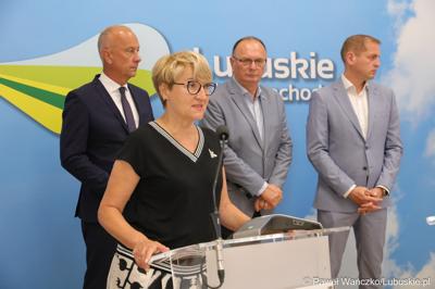 Marszałek Województwa Lubuskiego Elżbieta Anna Polak (przy mikrofonie) przemawia na konferencji prasowej. Z tyłu stoją (od lewej): Członek Zarządu Województwa Lubuskiego Marcin Jabłoński,  Wicemarszałek Województwa Lubuskiego Stanisław Tomczyszyn oraz Wicemarszałek Województwa Lubuskiego Łukasz Porycki.