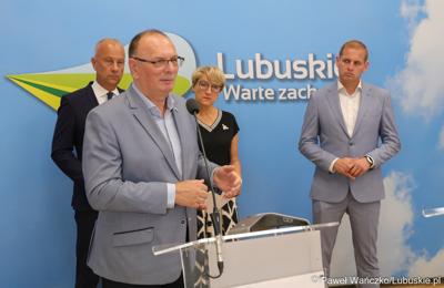Wicemarszałek Województwa Lubuskiego Stanisław Tomczyszyn przemawia podczas konferencji prasowej. Z tyłu stoją (od lewej): Członek Zarządu Województwa Lubuskiego Marcin Jabłoński, Marszałek Województwa Lubuskiego Elżbieta Anna Polak oraz Wicemarszałek Województwa Lubuskiego Łukasz Porycki.
