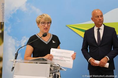 Marszałek Województwa Lubuskiego Elżbieta Anna Polak przemawia na konferencji prasowej. Z tyłu Członek Zarządu Województwa Lubuskiego Marcin Jabłoński.