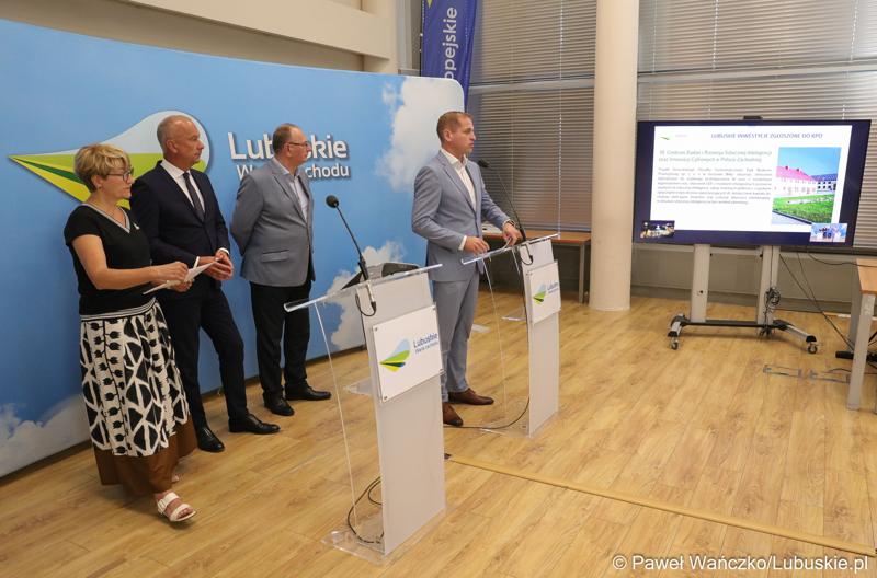 Wicemarszałek Województwa Lubuskiego Łukasz Porycki przemawia podczas konferencji prasowej. Z tyłu stoją (od lewej): Marszałek Województwa Lubuskiego Elżbieta Anna Polak, Członek Zarządu Województwa Lubuskiego Marcin Jabłoński oraz Wicemarszałek Województwa Lubuskiego Stanisław Tomczyszyn.