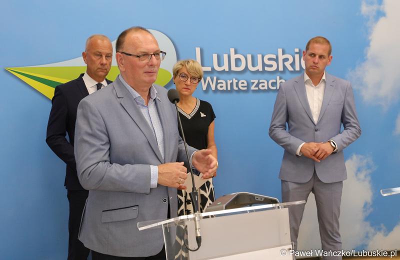 Wicemarszałek Województwa Lubuskiego Stanisław Tomczyszyn przemawia podczas konferencji prasowej. Z tyłu stoją (od lewej): Członek Zarządu Województwa Lubuskiego Marcin Jabłoński, Marszałek Województwa Lubuskiego Elżbieta Anna Polak oraz Wicemarszałek Województwa Lubuskiego Łukasz Porycki.