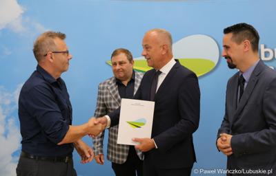 Członek Zarządu Województwa Lubuskiego Marcin Jabłoński (drugi z lewej) wręcza umowy przedstawicielom gmin i lubuskich powiatów 