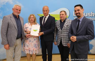 Członek Zarządu Województwa Lubuskiego Marcin Jabłoński (trzeci z prawej) wręcza umowy przedstawicielom gmin i lubuskich powiatów 